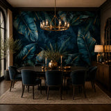 Tropical leaf mural in a moody dining room with dark chairs and brass chandelier