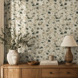 Watercolor eucalyptus wallpaper styled behind a sideboard with lamp and vase