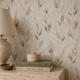 Wild meadow leaves wallpaper styled behind a table with lamp and books